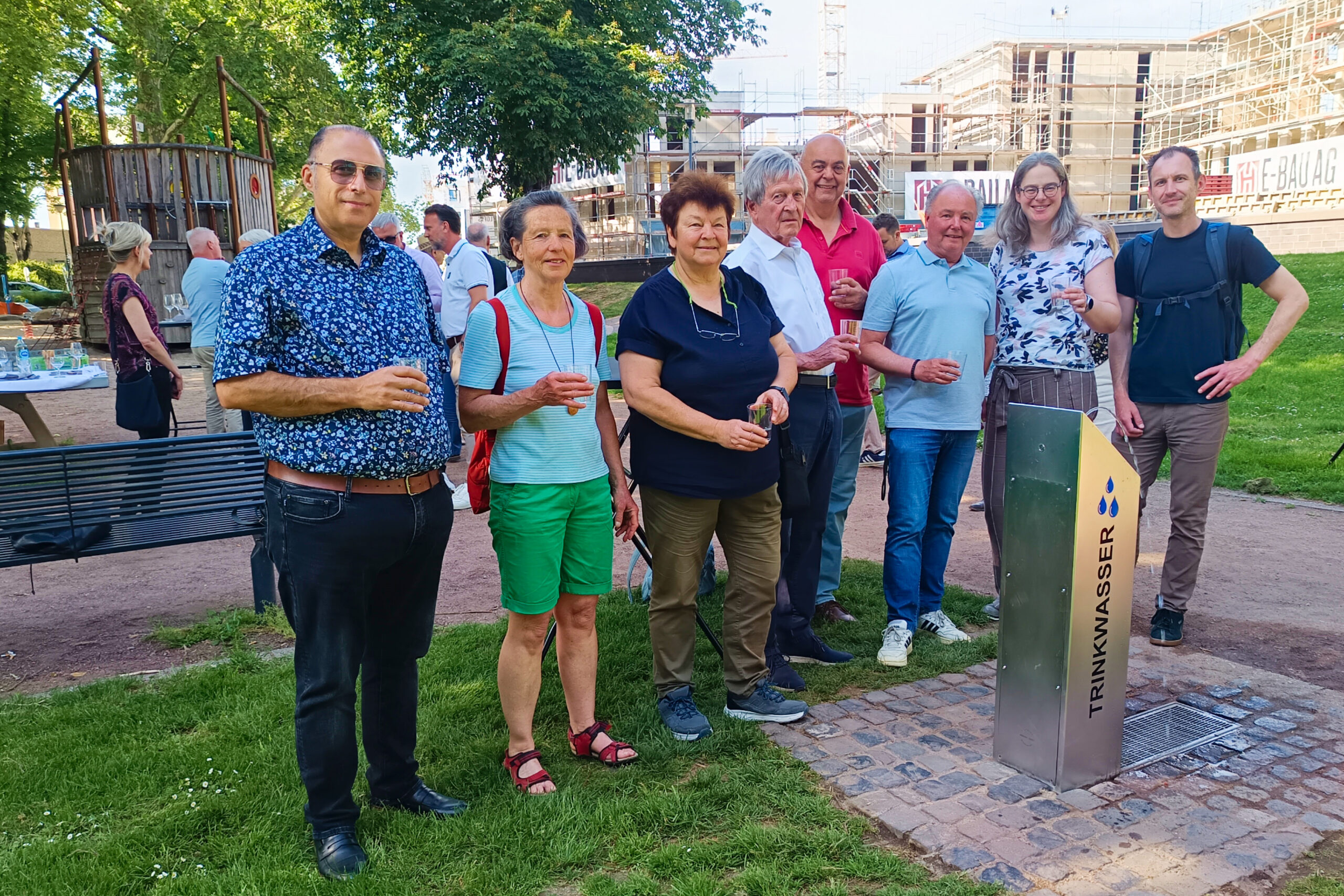 Mitglieder des Stadtumbaubeirats stehen vor dem Trinkwasserbrunnen in den Rheinanlagen